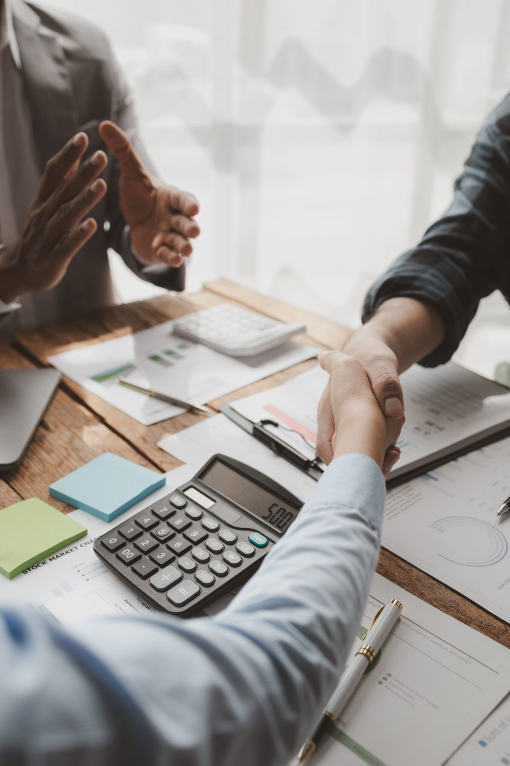 Couple shaking hands with accountant after successful tax resolution outcome